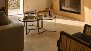 A modern living room with a wooden ceiling, a fireplace, a sofa, a coffee table, and a staircase. - Suite Terrasse 2 at Domaine de la Commanderie de Ballan (Ballan-Miré)