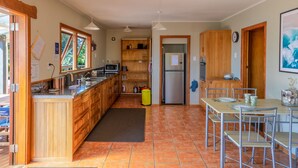 Eine kleine Küche mit Holzausstattung, einer eingebauten Mikrowelle und einem Kühlschrank.