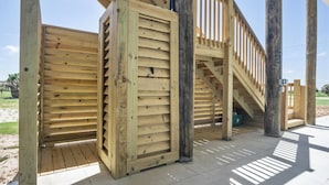 Une terrasse en bois avec un escalier menant à un niveau supérieur.