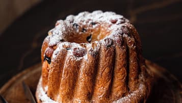 Un gâteau en forme de couronne, posé sur une planche en bois, avec un couteau à côté.