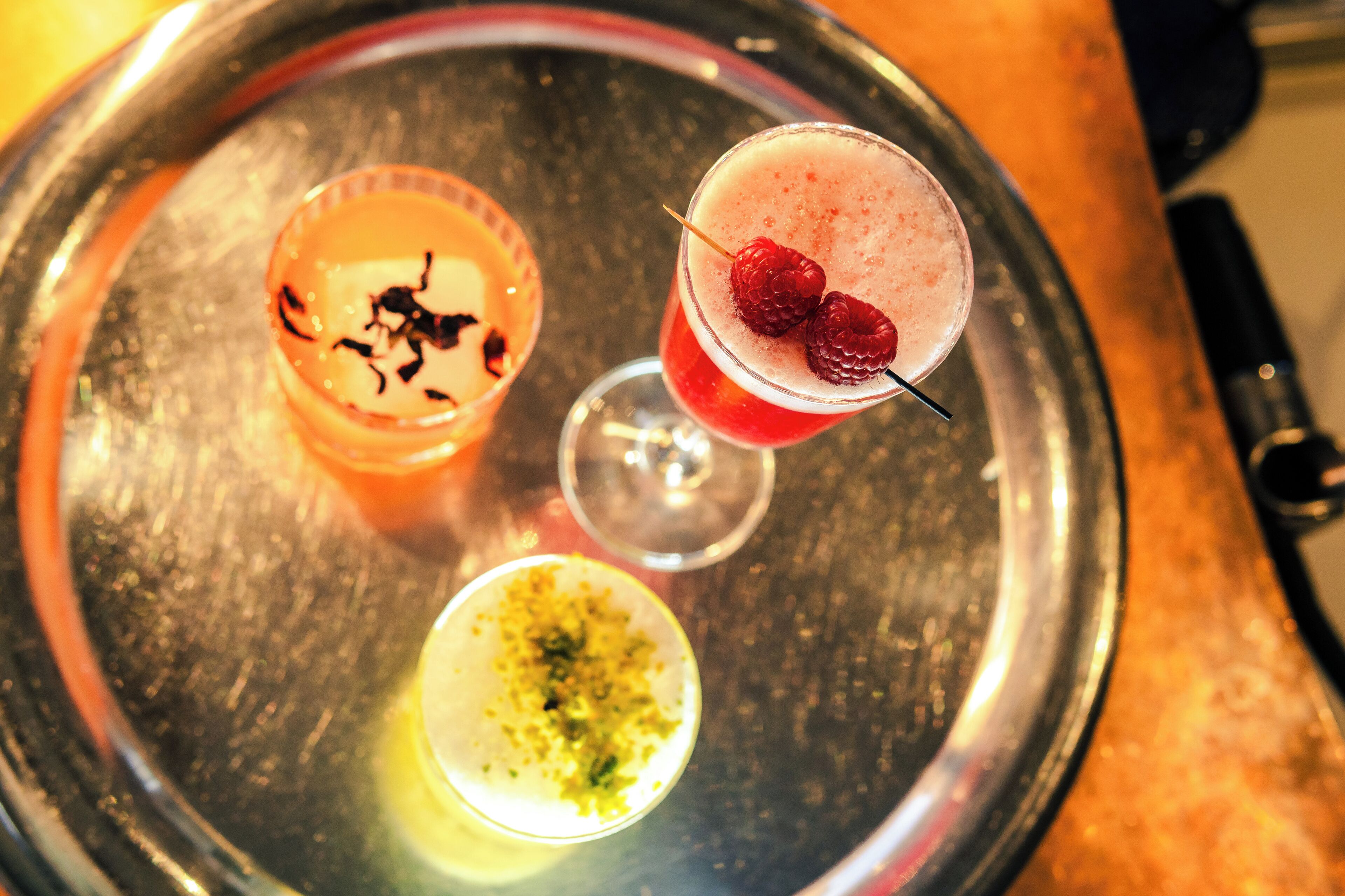 Three drinks on a metal tray.