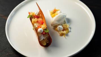 A white plate with two desserts on a dark surface.