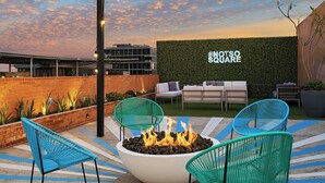 An outdoor seating area with a fire pit, chairs, and a wall with text.