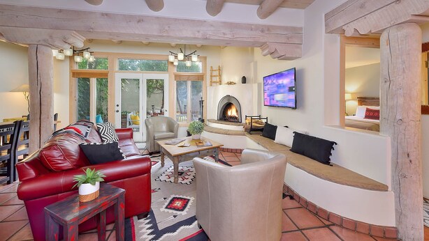 A cozy living room with a fireplace, leather sofa, and a TV mounted on the wall. - Zona Rosa 71, San Rafael (Santa Fe)