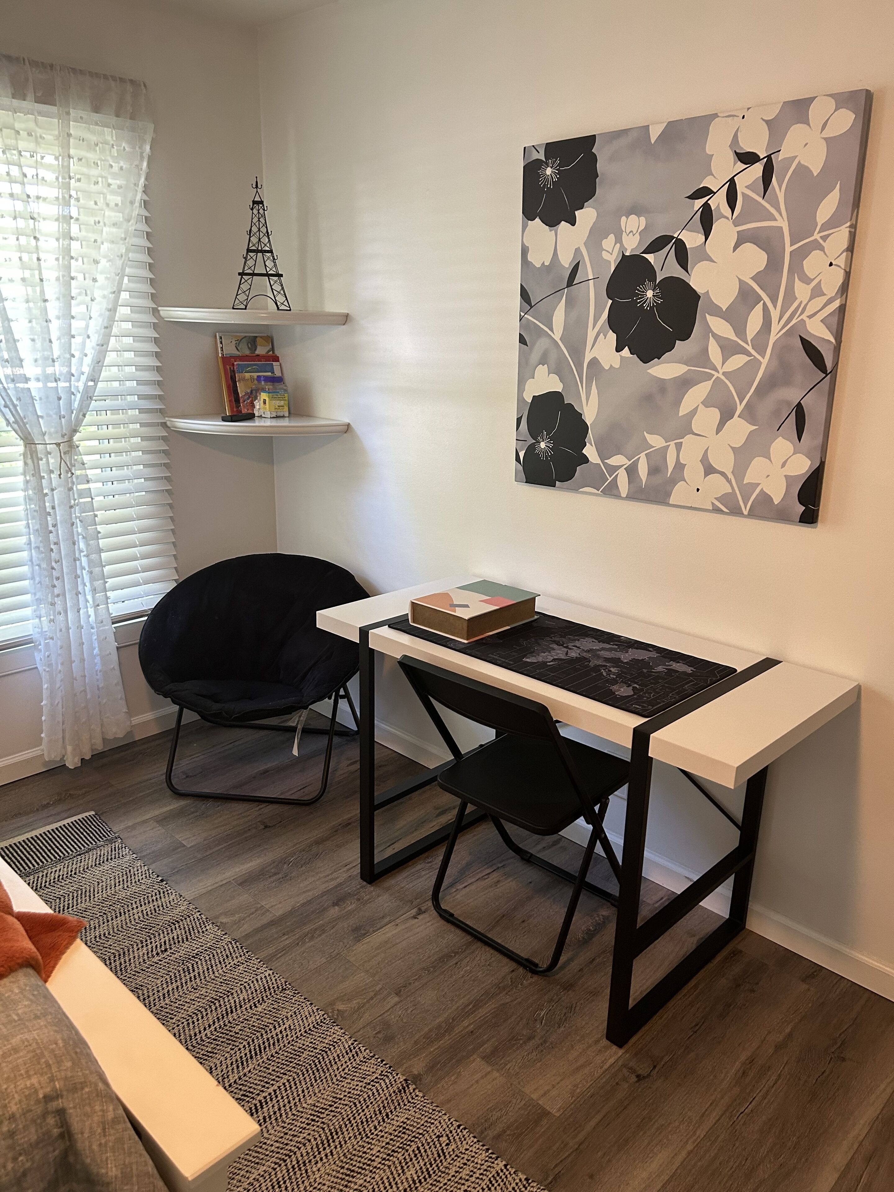 A modern room with a desk, chair, and a decorative wall piece.