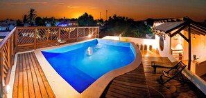 Una piscina al aire libre, sillones reclinables de piscina