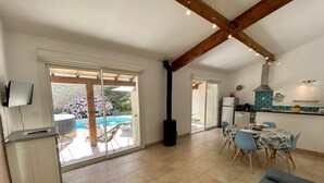 Amplia sala de estar con piscina, mesa de comedor y zona de cocina.