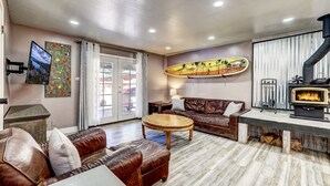Ein gemütliches Wohnzimmer mit Kamin, Ledersofas, einem Couchtisch und Kunstwerken an den Wänden.