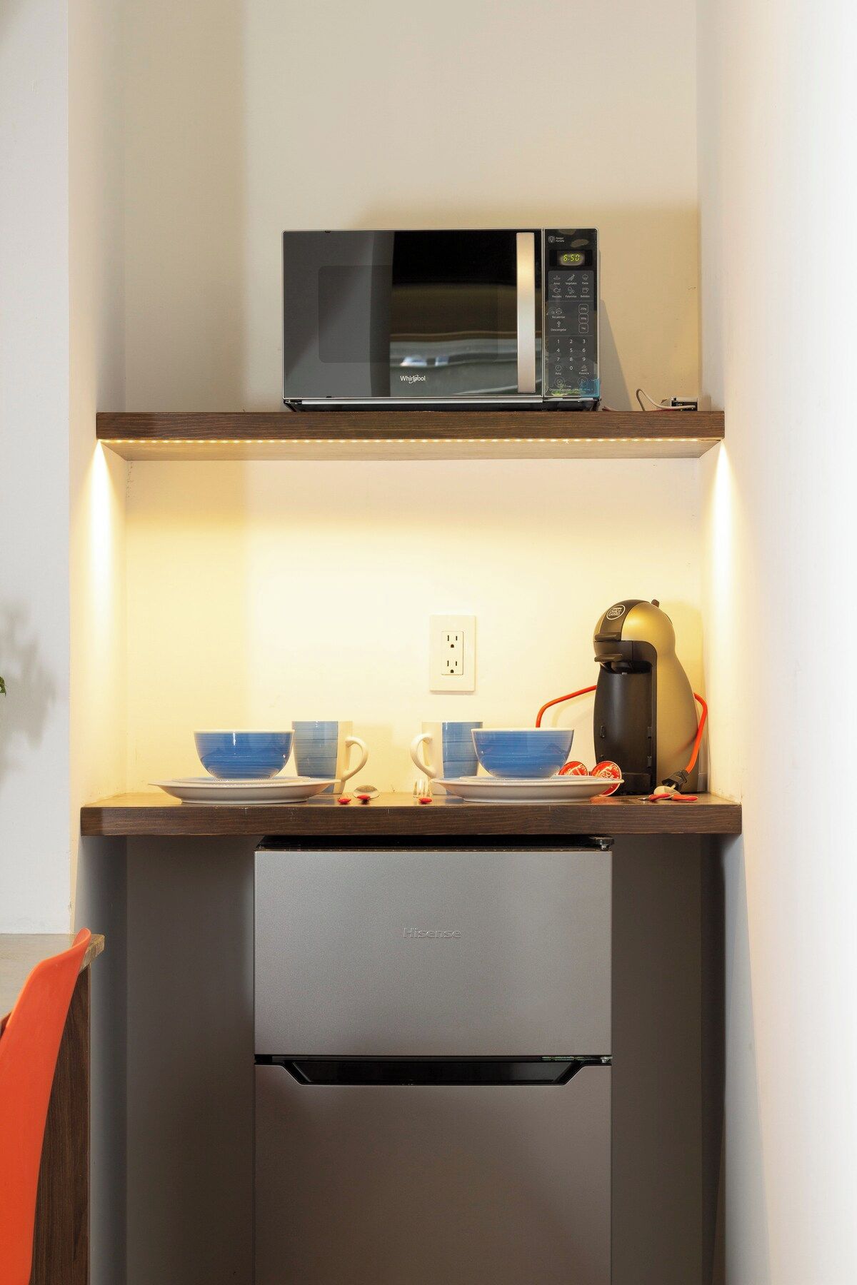 A compact kitchenette with a microwave, a coffee maker, and a refrigerator.