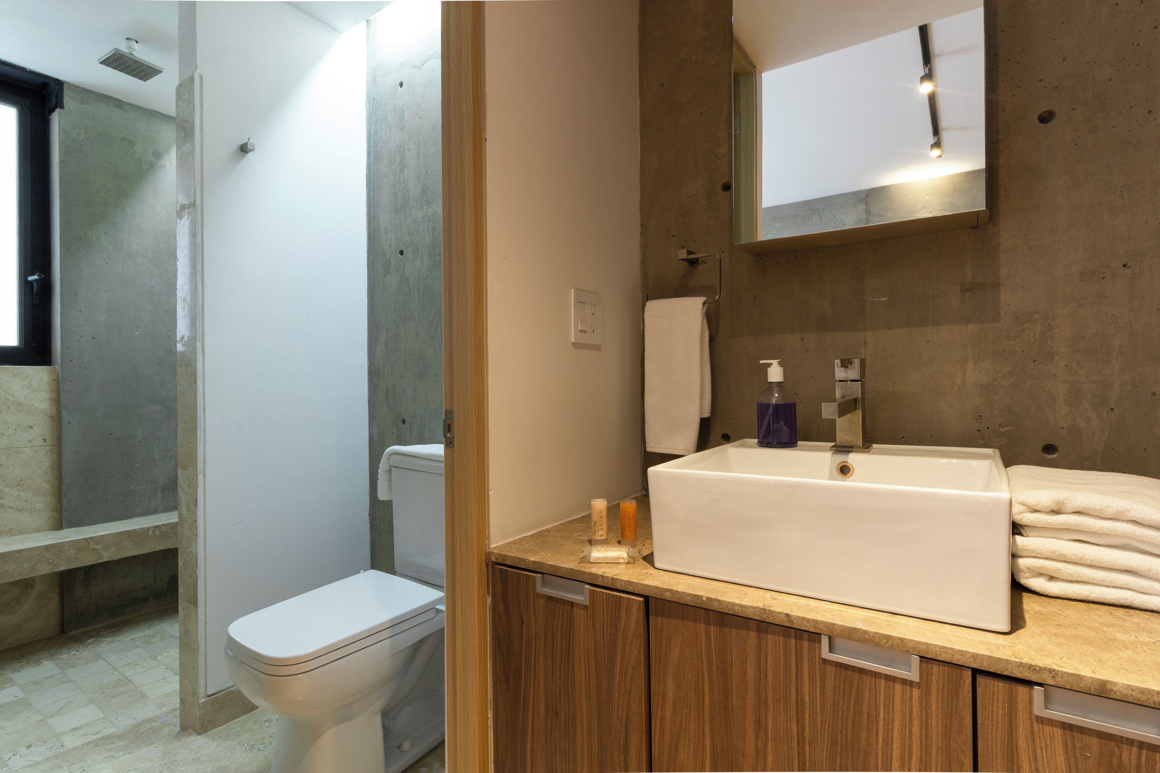 A modern bathroom with a toilet, sink, and mirror.