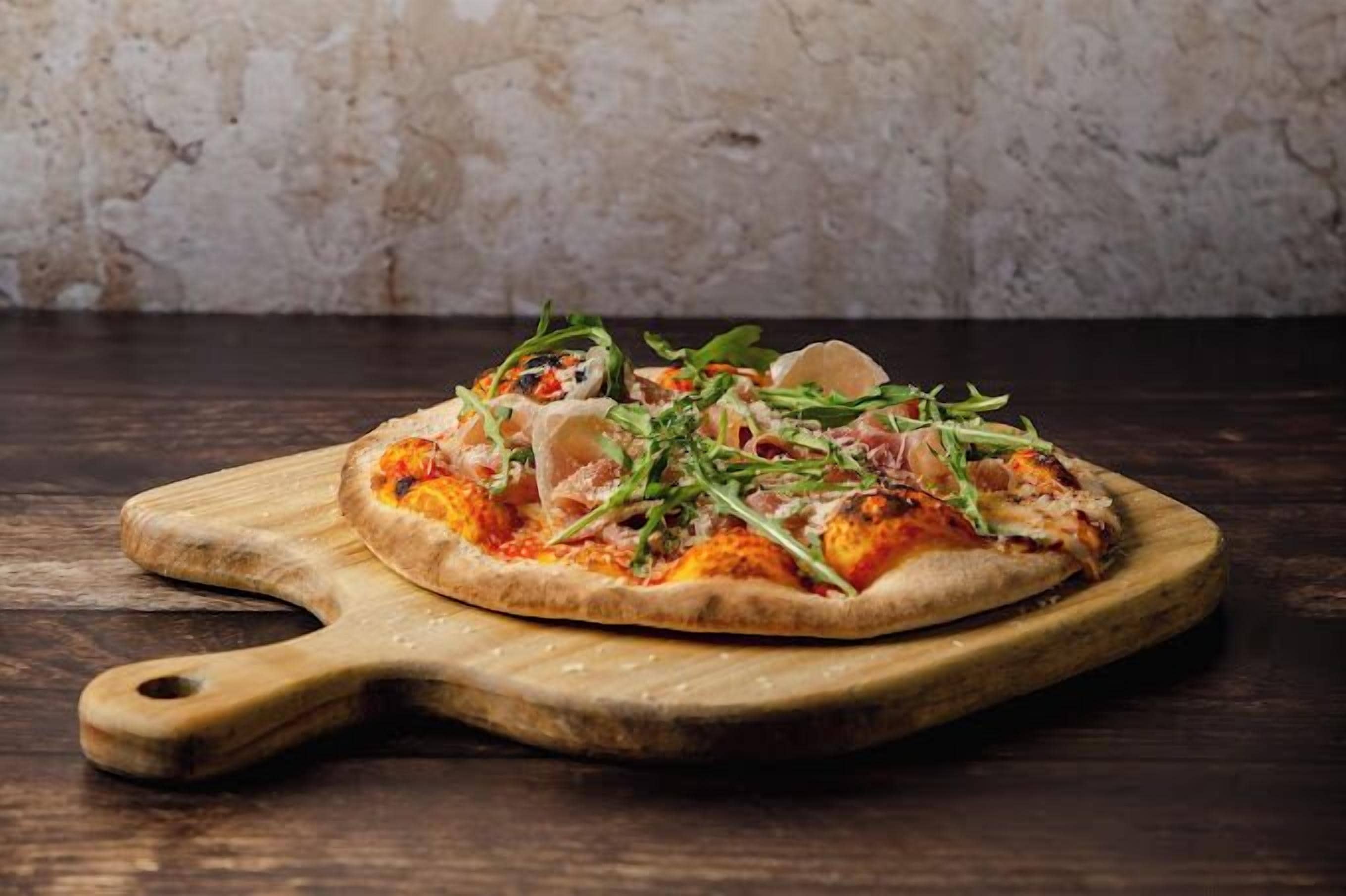 A pizza on a wooden board.