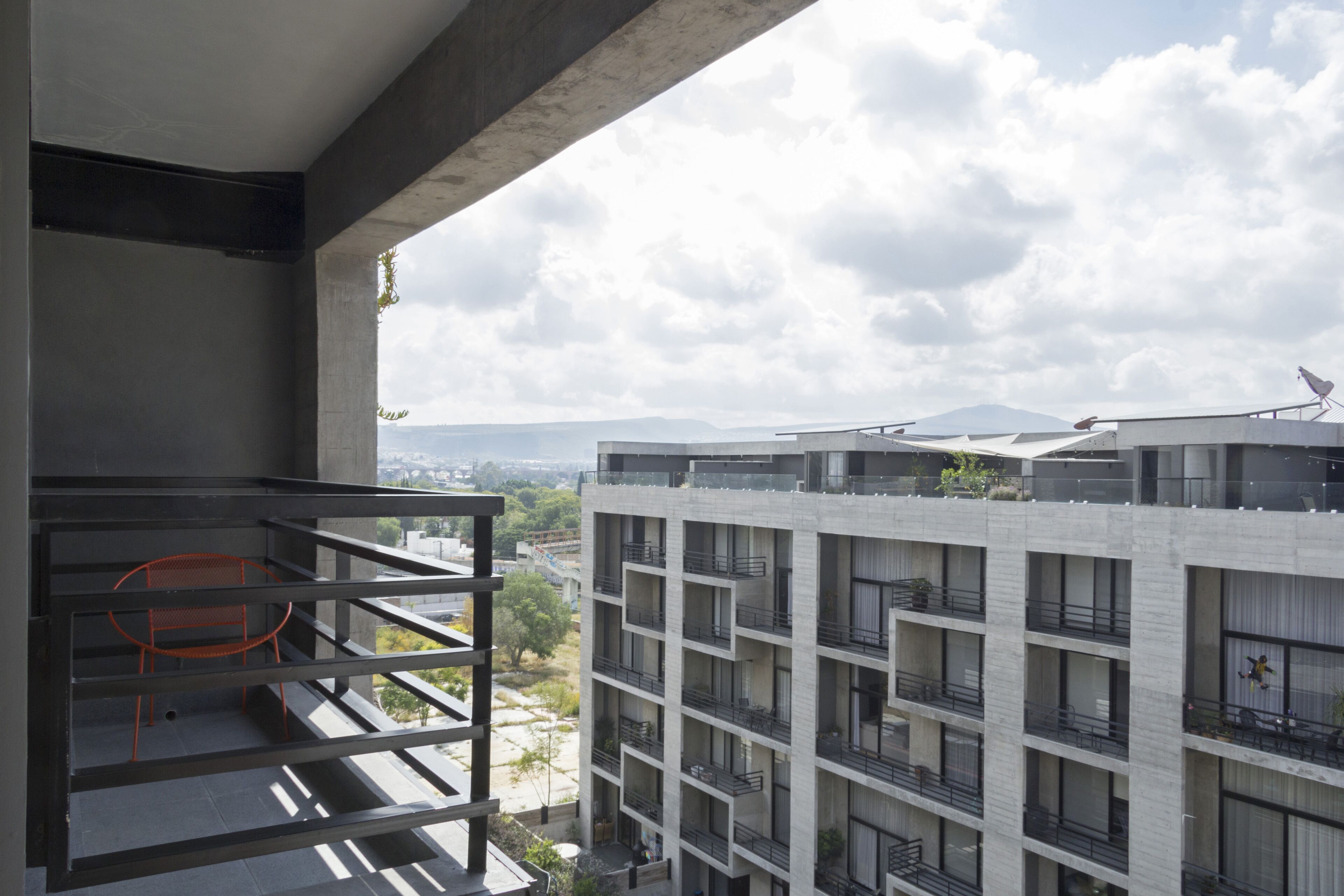 A modern building with multiple balconies and a view of the cityscape.