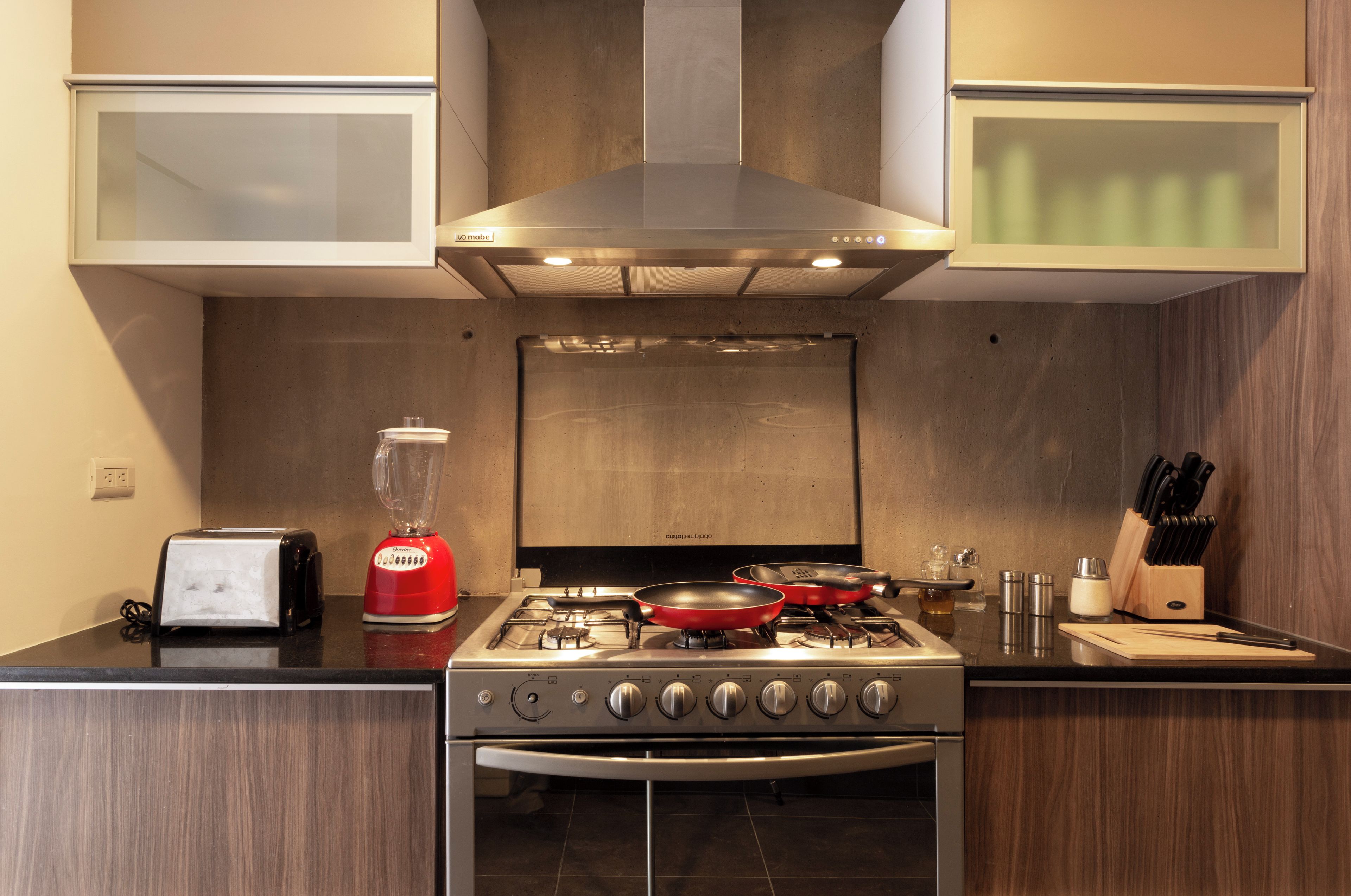 A modern kitchen with a gas stove, oven, and a blender on the countertop.
