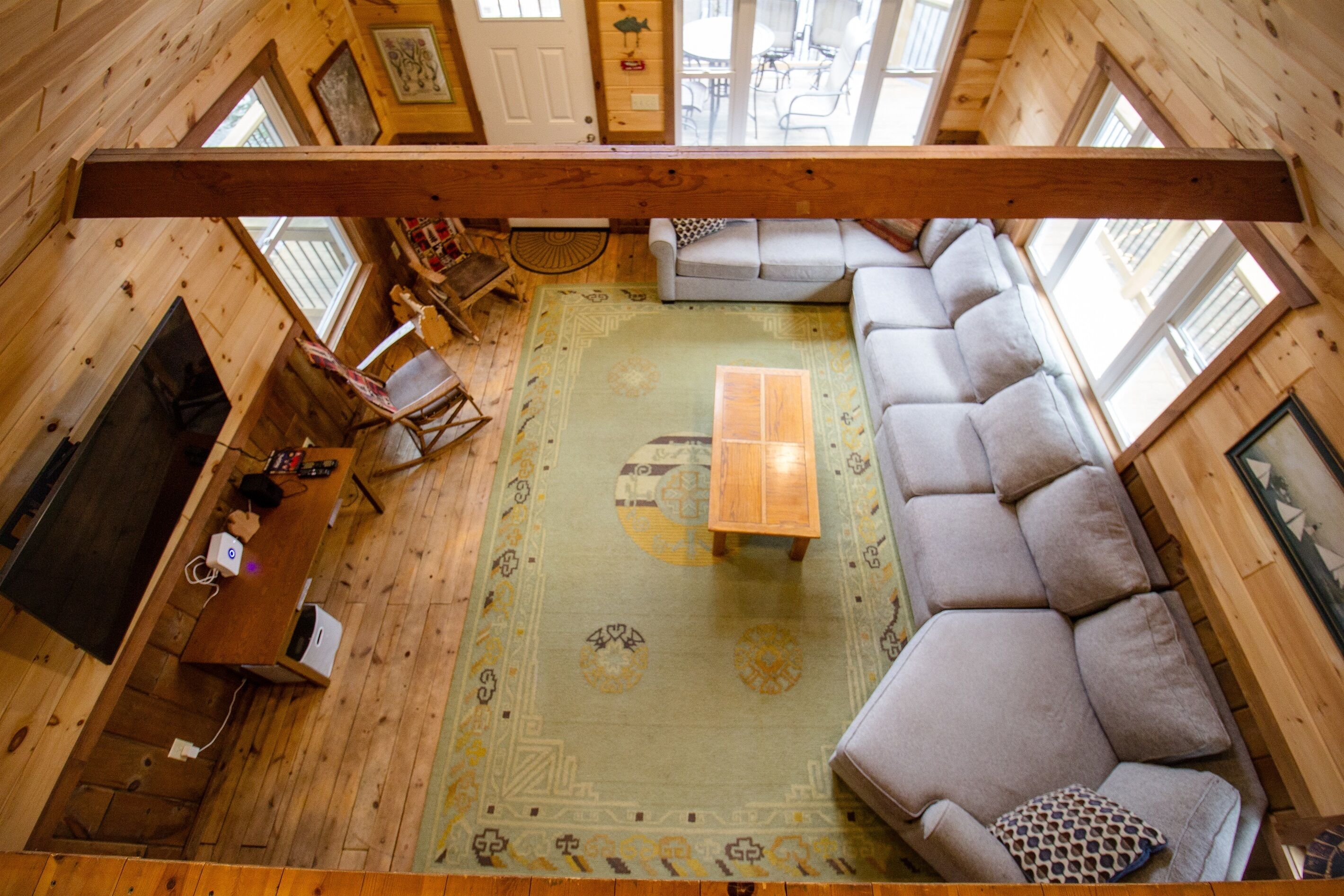 A cozy cabin interior with a sofa, a wooden table, and a television.