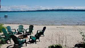 A beach with green Adirondack chairs and a fire pit. - Right on the Lake Michigan - walk to town and across from TART trail (Suttons Bay)