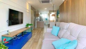 Una sala de estar moderna con un sofá, un televisor y una alfombra azul.