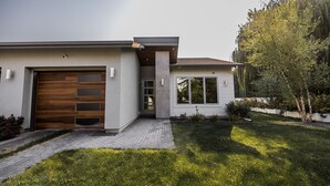 A modern two-story house with a garage, a covered entryway, and a well-maintained lawn. - Modern Holistic Home - Near the Village & Shopping!  (Meridian)