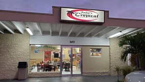 Un restaurante llamado Julio's Cafe Tropical con un cartel sobre la entrada y el número 307 en la puerta.
