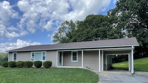 A single-story house with a covered porch, a front lawn, and a driveway. - We are located in the beautiful blue ridge mountains (Sparta)
