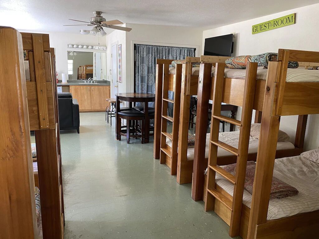 Une chambre d’hôtes équipée de lits superposés, d’un bureau et d’une kitchenette.