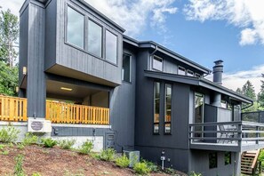 Et moderne hus med to etager, balkon, store vinduer og skorsten.