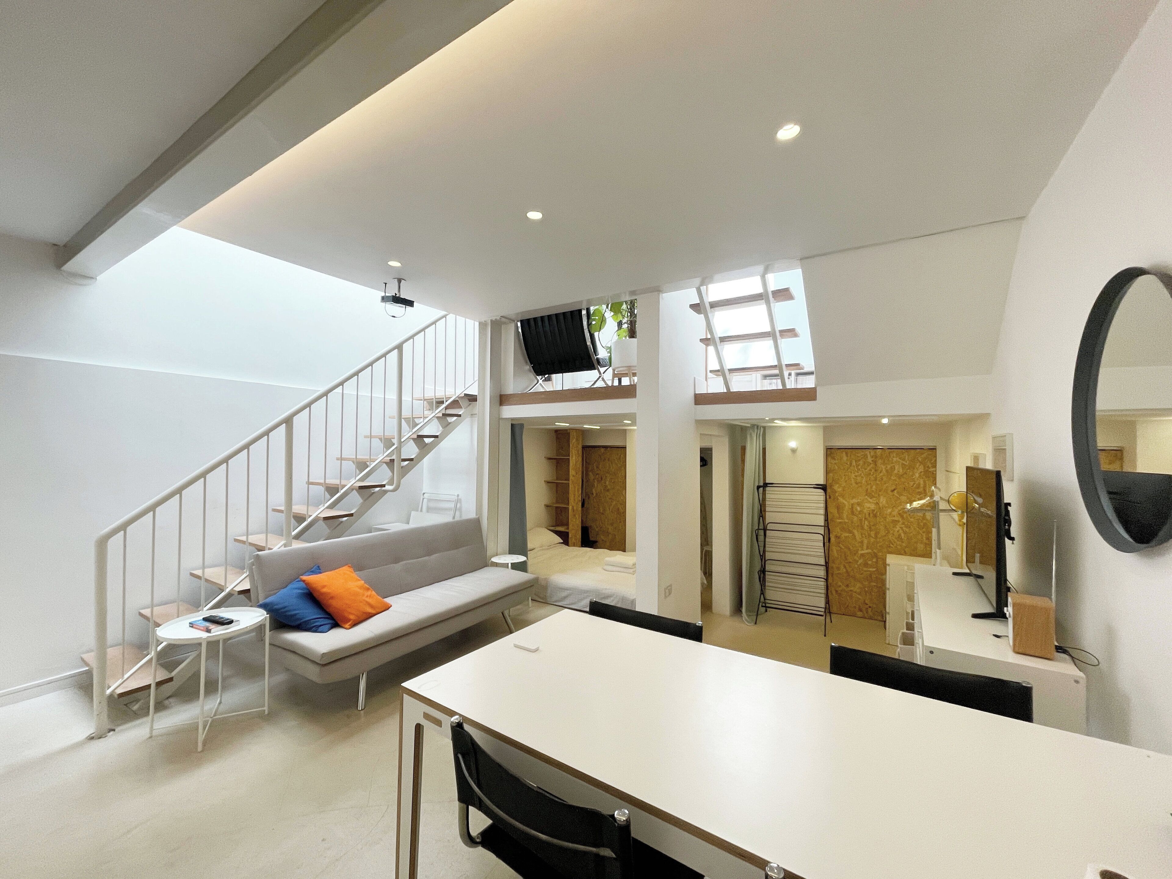 Living / Dining area with sofa bed, large TV and radio at basement level