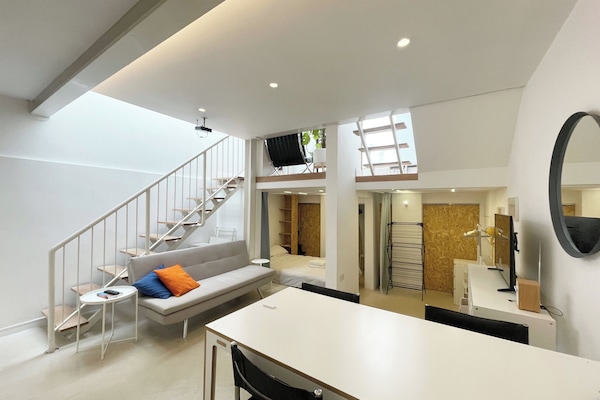 Living / Dining area with sofa bed, large TV and radio at basement level