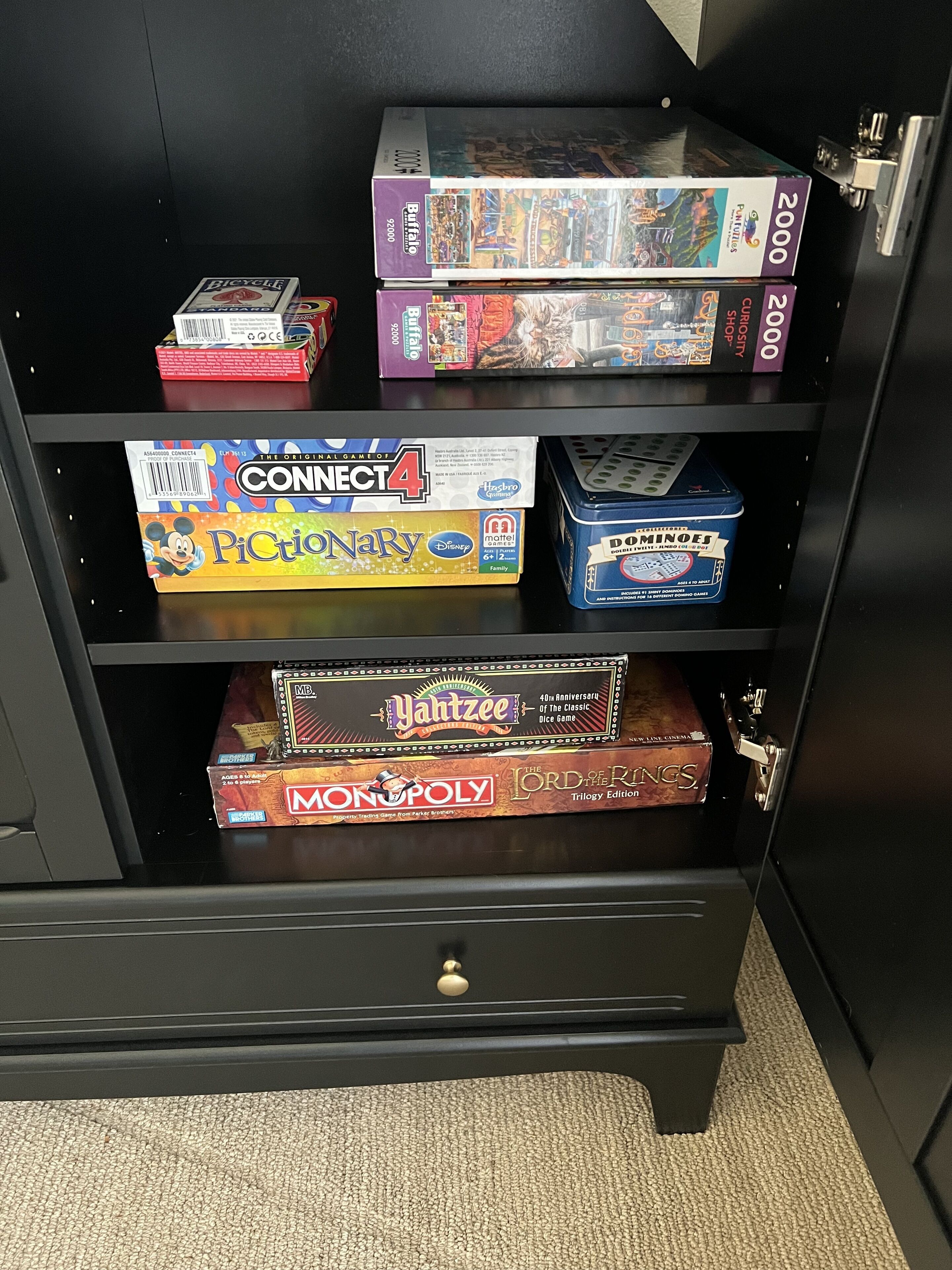 Kirjahylly, jossa on useita erilaisia lautapelejä, kuten Connect 4, Monopoly ja muita.