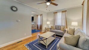 A living room with a ceiling fan, a sofa, a coffee table, and a rug.