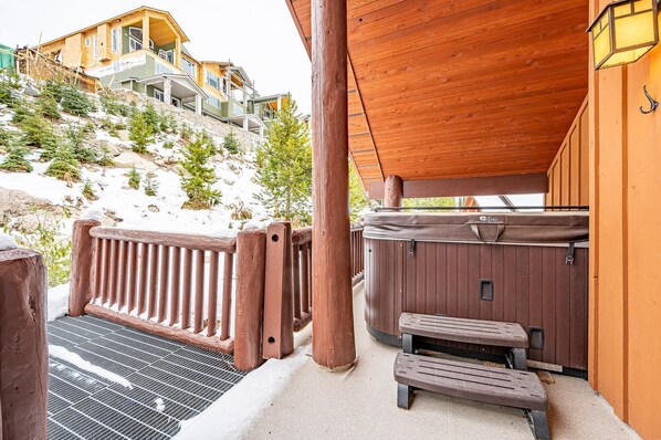 A wooden deck with a hot tub, a bench, and a metal grill. - Trapper's Lodge 4 Bd W/great View, Private Hot Tub (Beaverdell)