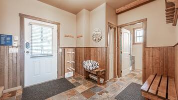 Experience a blend of traditional and modern elements in this inviting hallway, featuring a bench and leading to a door with a window.