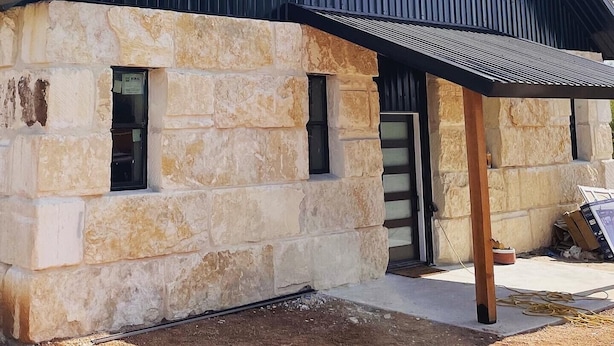 A building with a stone facade and a metal roof. - The Rock Stack: Ruggedly luxurious 3 bedroom, 3 bathroom on the Llano River (Llano)