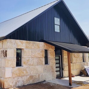 Un bâtiment doté d’une façade en pierre et d’un toit en métal.