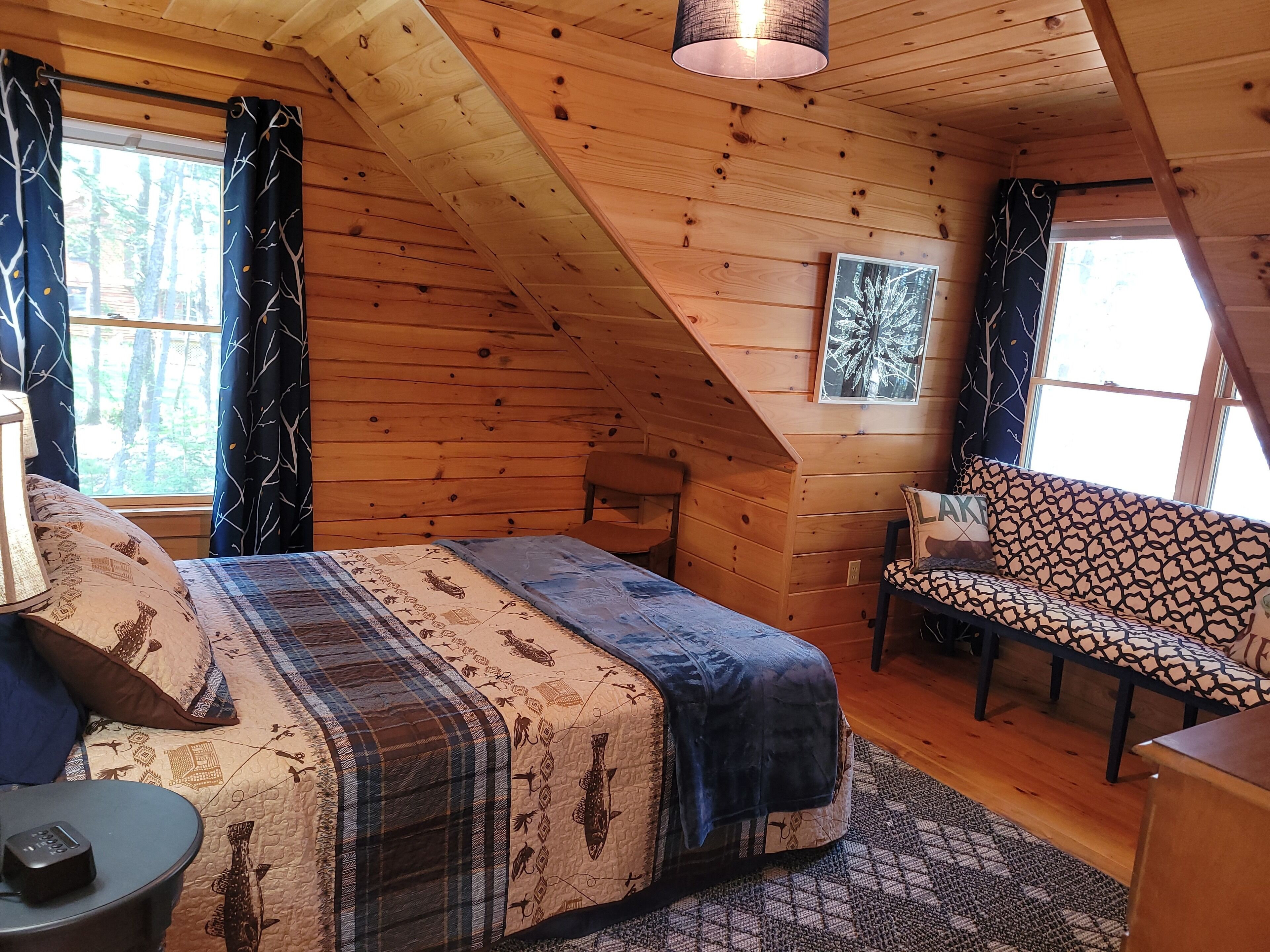 A cozy attic bedroom with a bed, a bench, and a desk.