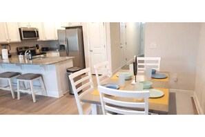 Enjoy meals in the kitchen and dining area, equipped with a refrigerator, microwave, oven, and dining table.
