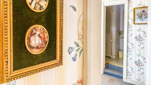 A room with two framed artworks on the wall and floral wallpaper.