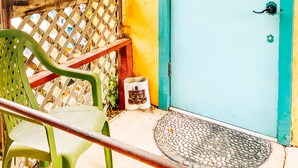 A door with a "No Smoking" sign, a green chair, and a small decorative item on the ground.