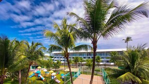 A resort with a pool area, palm trees, and a building with multiple floors. - Ancorar Flat Resort (Ipojuca)