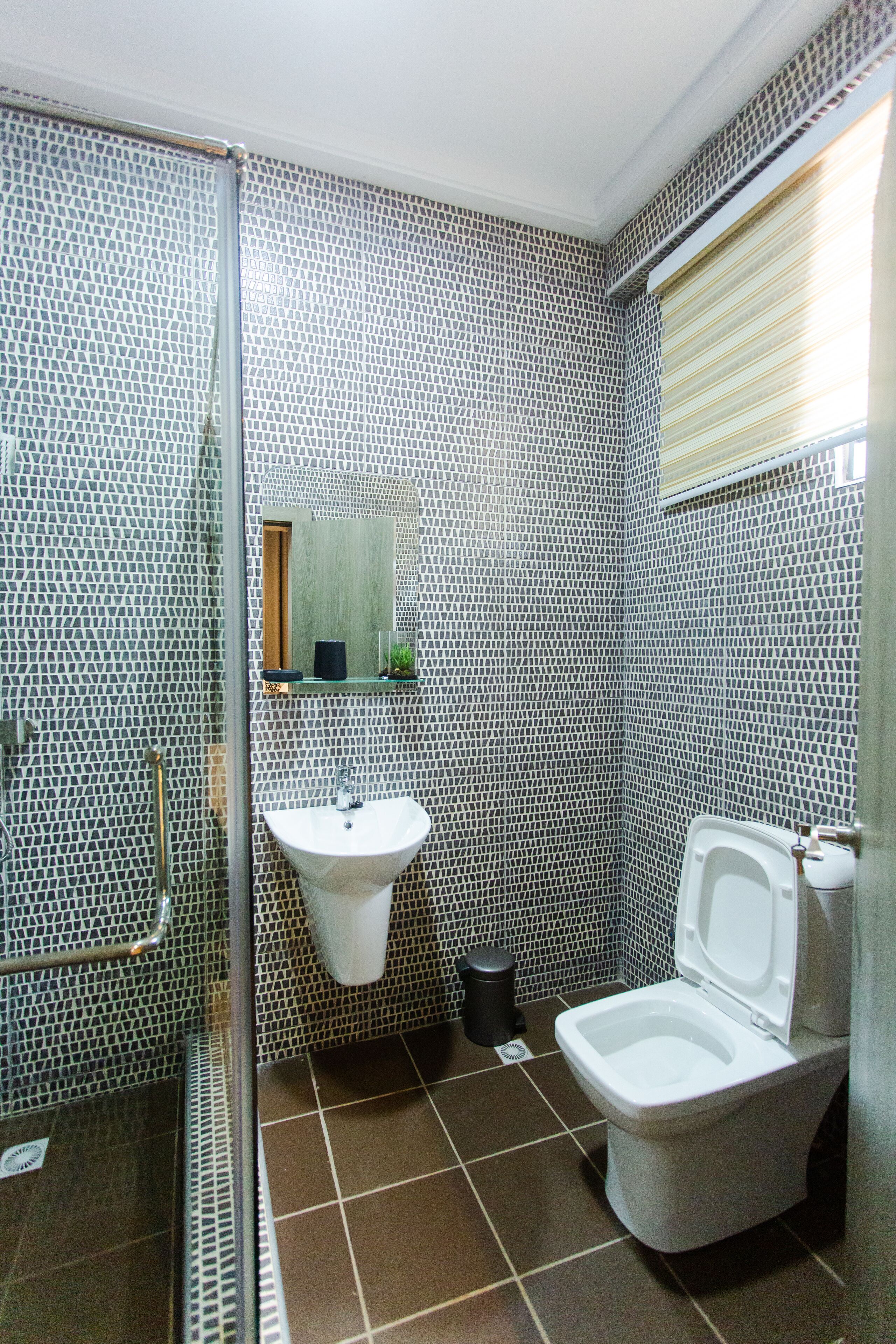 A bathroom with a shower, sink, and toilet.
