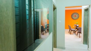 Un interior moderno con una escalera que conduce a un área de comedor, con un reloj en la pared.