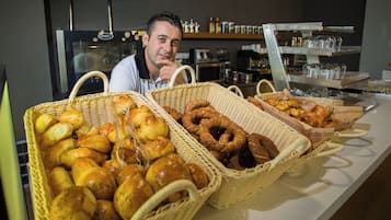A bakery display with various baked goods in wicker baskets.