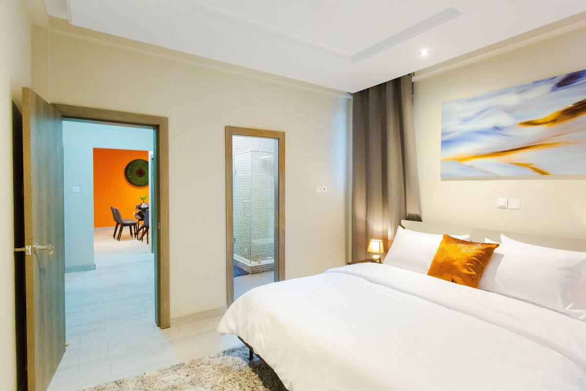 Une chambre d’hôtel avec un lit, un tableau et une vue sur la salle à manger.