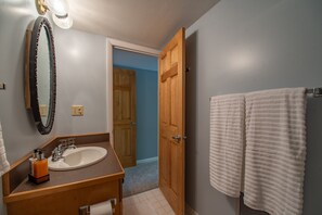 Een badkamer met een houten wastafelmeubel, een wastafel, een spiegel en een handdoekrek.