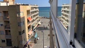 A coastal hotel with multiple floors, balconies, and a view of the sea.