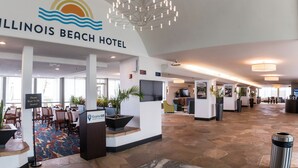 Vestíbulo del Illinois Beach Hotel con una recepción, zona de estar y un ventanal grande.