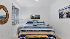Cozy retreat with a large bed, round mirror, and bedside table.