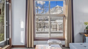 Una habitación con un ventanal grande, una mesa de madera y un sofá.