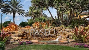 A stone wall with the word "PASEO" and a small waterfall.