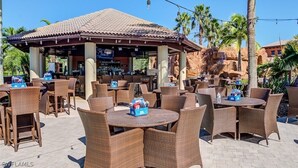 An outdoor seating area with wicker furniture and a covered bar area.