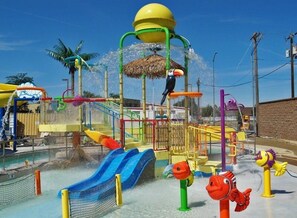 A water park with slides, a climbing structure, and a bird perched on the top. - Comfort Meets Affordability, Free Parking, Outdoor Pool, Pets Allowed (Kennewick)